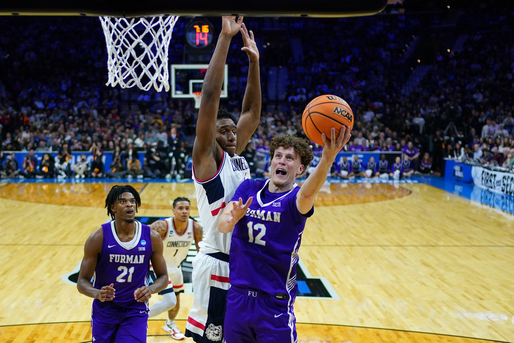Furman's Tom House, right, goes up for a shot against UConn's Tarris Reed Jr. during the first half in the first round of the NCAA college basketball tournament, Friday, March 20, 2026, in Philadelphia. (AP Photo/Matt Slocum)