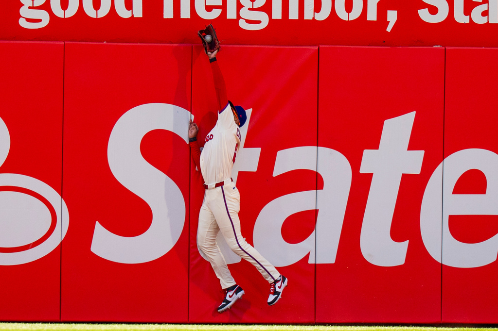 Philadelphia Phillies center fielder Justin Crawford leaps to catch the fly ball by Texas Rangers' Wyatt Langford during the third inning of a baseball game, Saturday, March 28, 2026, in Philadelphia. (AP Photo/Chris Szagola)