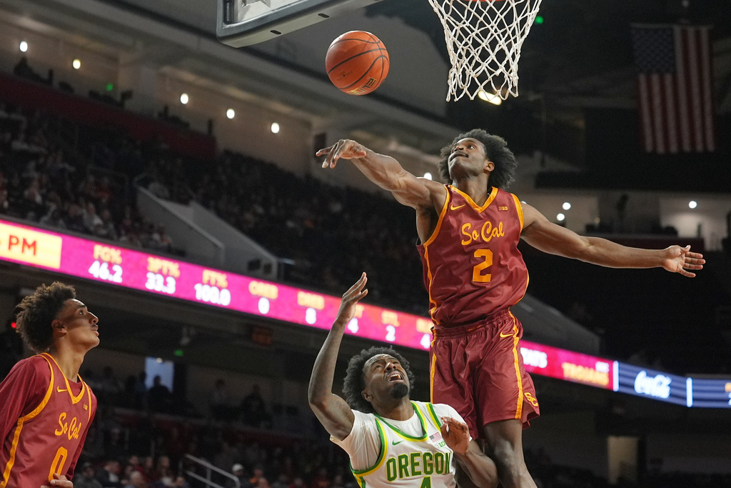 Southern California forward Ezra Ausar (2) blocks a shot by Oregon forward Dezdrick Lindsay (4) during the first half of an NCAA college basketball game Saturday, Feb. 21, 2026, in Los Angeles. (AP Photo/Damian Dovarganes)