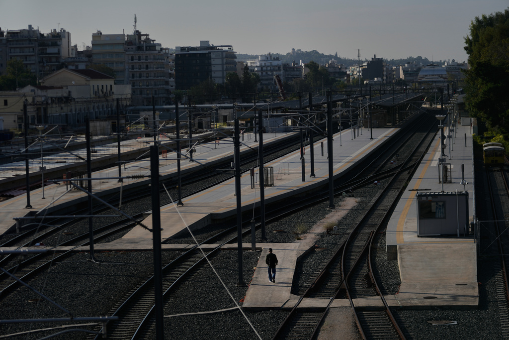 A man walks at the closed Greek capital's main railway station during a nationwide 24-hour strike in Athens, Greece, Tuesday, Oct. 14, 2025, as labor unions demand higher wages and the withdrawal of a bill changing work hours. (AP Photo/Petros Giannakouris)
