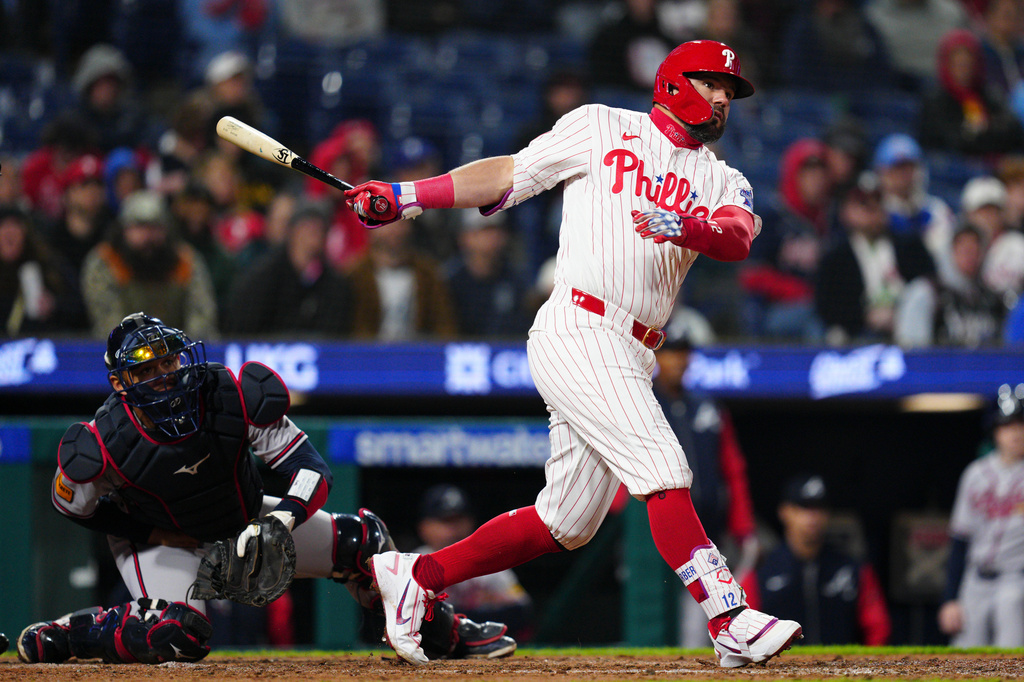 Philadelphia Phillies' Kyle Schwarber, right, watches his double off Atlanta Braves pitcher Aaron Bummer during the fifth inning of a baseball game, Sunday, April 19, 2026, in Philadelphia. (AP Photo/Derik Hamilton)
