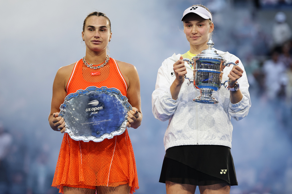 Aryna Sabalenka, of Belarus, left, and Elena Rybakina, of Kazakhstan, right, hold up their trophies after Rybakina won the women's singles final of the U.S. Open tennis championships Saturday, Sept. 12, 2026, in New York. (AP Photo/Adam Hunger)