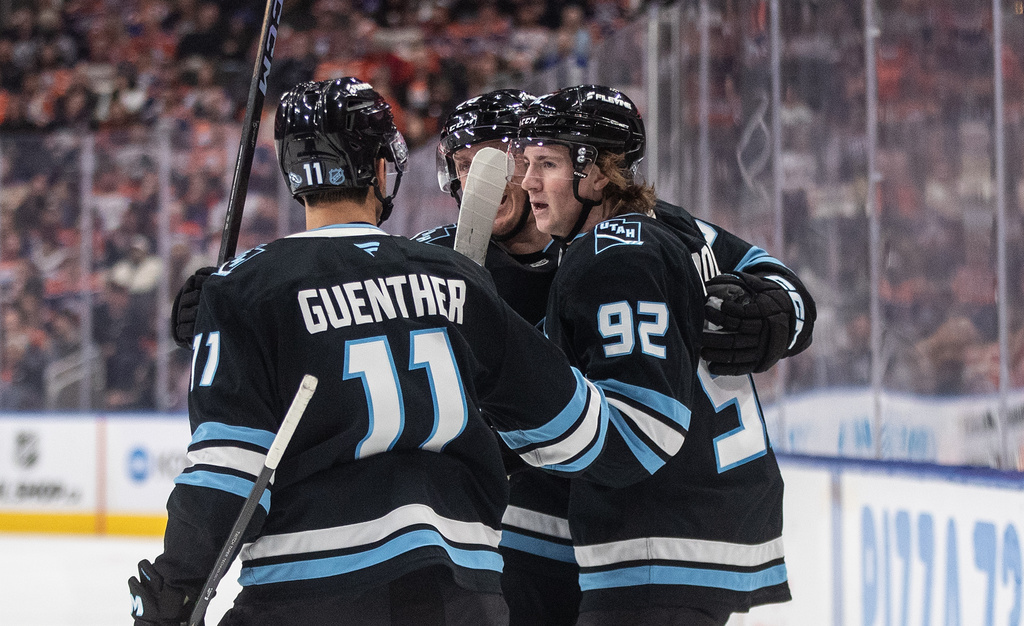 Utah Mammoth's Dylan Guenther (11), Logan Cooley (92) and Mikhail Sergachev (98) celebrate a goal against the Edmonton Oilers during first period NHL action, in Edmonton on Tuesday, October 28, 2025. (Jason Franson/The Canadian Press via AP)