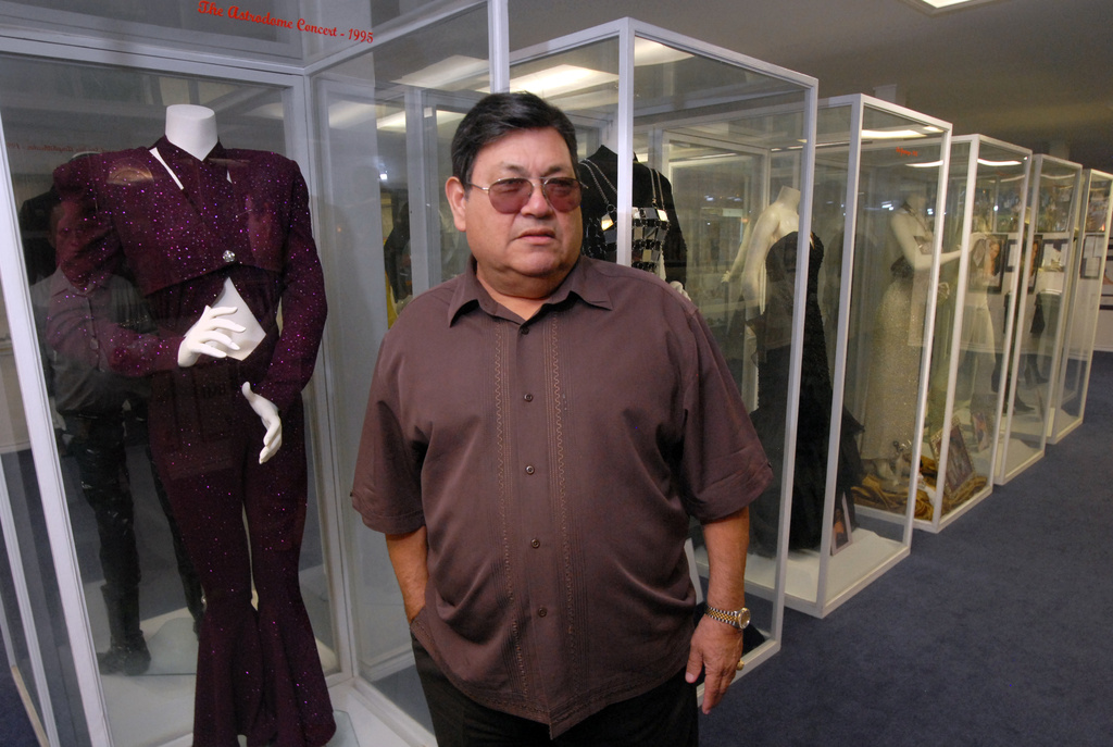 FILE - Abraham Quintanilla, father of late singer Selena, appears in front of costumes worn by Selena in Corpus Christi, Texas on June 24, 2011. (AP Photo/Paul Iverson, File)