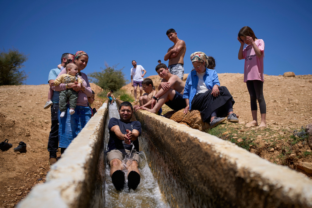 A man slides down into a spring as Israeli settlers and others enjoy a day in the Jordan Valley during Israel's Independence Day, in Auja, in the occupied West Bank, Wednesday, April 22, 2026.(AP Photo/Ohad Zwigenberg)