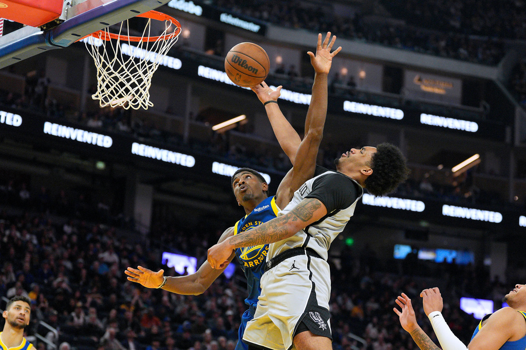 San Antonio Spurs guard Dylan Harper, right, drives to the basket against Golden State Warriors guard Nate Williams, left, during the first half of an NBA basketball game in San Francisco, Wednesday, April 1, 2026. (AP Photo/Tony Avelar)