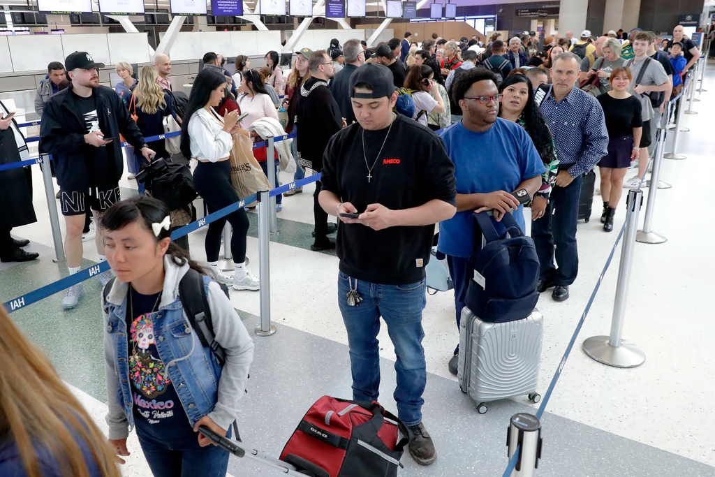 Air travelers endure long lines and two-hour wait times at the TSA security check point at Terminal E at the George Bush Intercontinental Airport Friday, March 20, 2026, in Houston. (AP Photo/Michael Wyke)