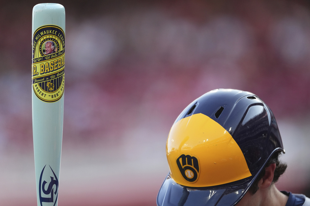 Milwaukee Brewers' Christian Yelich stands in the on-deck circle, holding a custom bat for Players' Weekend, in the first inning of a baseball game against the Cincinnati Reds, Friday, Aug. 15, 2025, in Cincinnati. (AP Photo/Kareem Elgazzar)