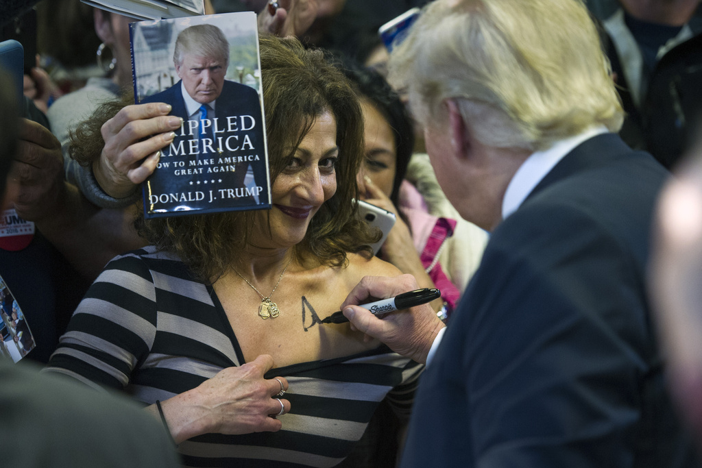 FILE - Then-Republican presidential candidate Donald Trump autographs a supporter's chest following his speech at a campaign rally at the Prince William County Fair Ground, Wednesday, Dec. 2, 2015, in Manassas, Va. (AP Photo/Cliff Owen, File)