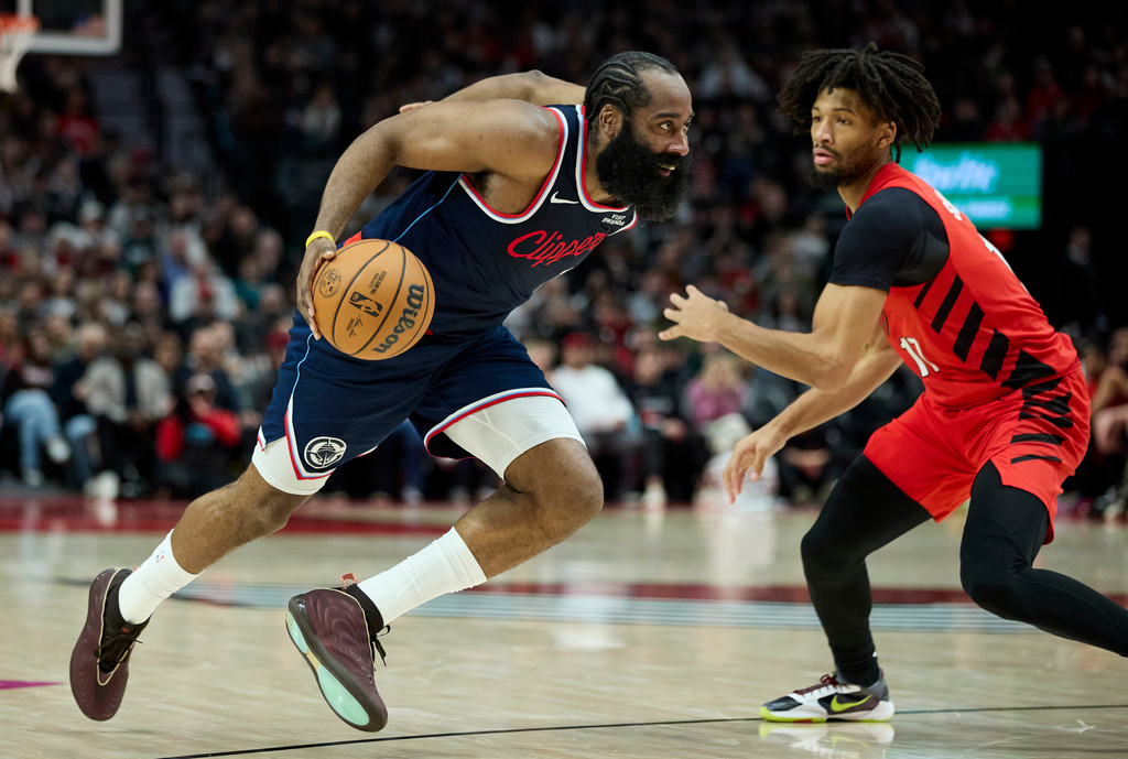 Los Angeles Clippers guard James Harden, left, dribbles past Portland Trail Blazers guard Shaedon Sharpe during the second half of an NBA basketball game in Portland, Ore., Friday, Dec. 26, 2025. (AP Photo/Craig Mitchelldyer)