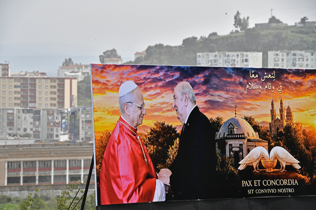 A banner showing a photo of Pope Leo XIV and Algerian President Abdelmadjid Tebboune in Annaba, eastern Algeria, Saturday, April 11, 2026, ahead of Pope Leo XIV's visit. The banner in Arabic reads, "Let's live in peace and harmony." (AP Photo/Fateh Guidoum)