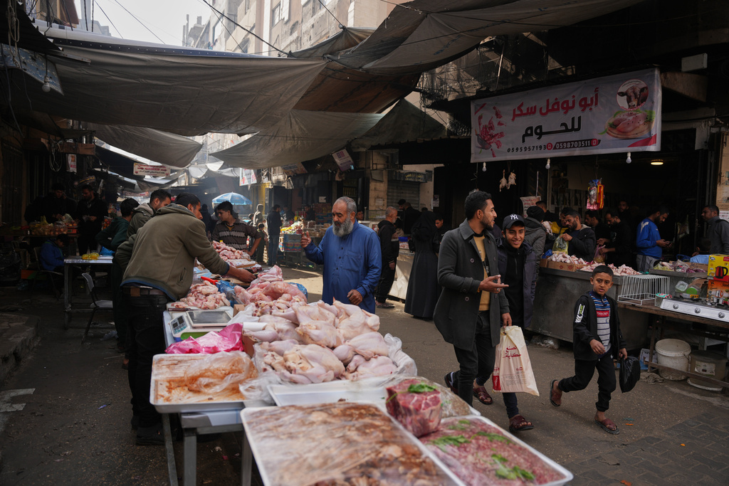 A Palestinian looks at chicken cuts displayed for sale at a local street market in Gaza City, Friday, Dec. 19, 2025. (AP Photo/Abdel Kareem Hana)
