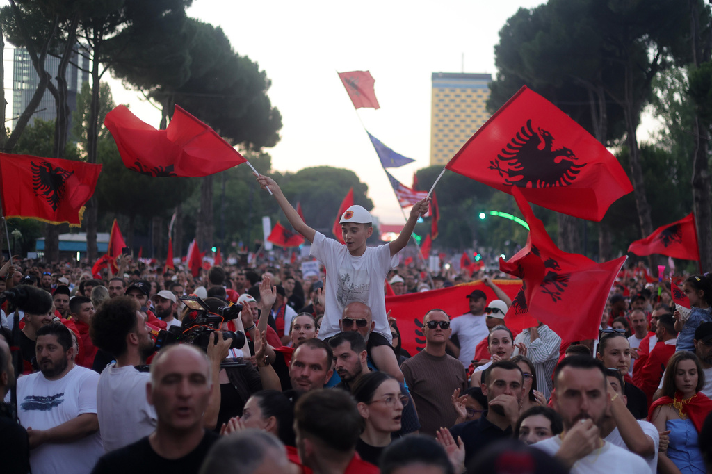 A youth waves Albanian flags during a rally in Tirana, Saturday, June 20, 2026, against a coastal development project in western Albania linked to Donald Trump's son-in-law Jared Kushner, which is facing growing opposition from environmental advocates and has triggered daily protests in the Albanian capital. (AP Photo/Hameraldi Agolli)
