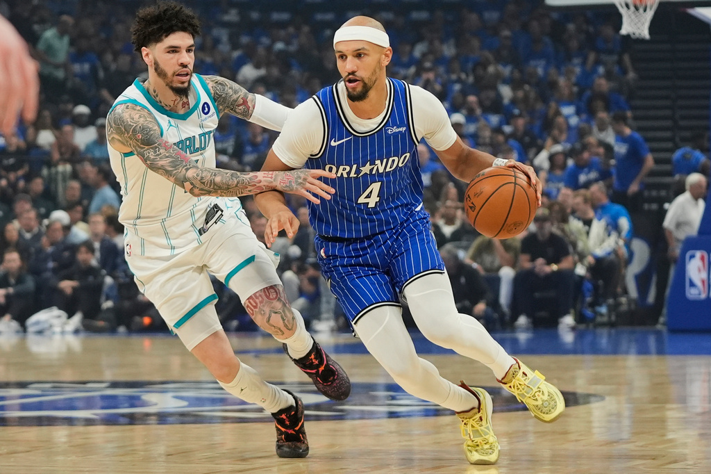 Orlando Magic guard Jalen Suggs (4) drives around Charlotte Hornets guard LaMelo Ball during the first half of an NBA play-in tournament basketball game, Friday, April 17, 2026, in Orlando, Fla. (AP Photo/John Raoux)