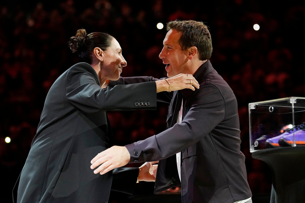 Retired Phoenix Mercury WNBA basketball player Diana Taurasi, left, hugs Phoenix Suns and Mercury owner Mat Ishbia as Taurasi is honored during a halftime Ring of Honor ceremony Sunday, Aug. 16, 2026, in Phoenix. (AP Photo/Ross D. Franklin)