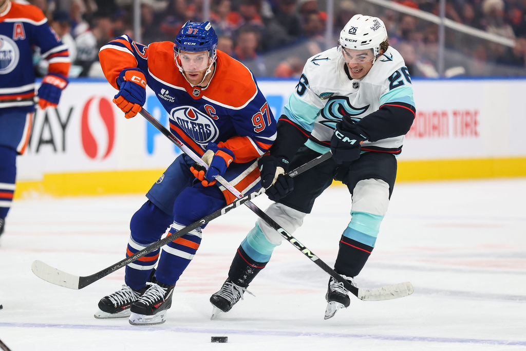 Edmonton Oilers' Connor McDavid (97) battles against Seattle Kraken's Ryan Winterton (26) during the second period of an NHL hockey game in Edmonton, Alberta, Saturday, Oct. 3, 2026. (Codie McLachlan/The Canadian Press via AP)