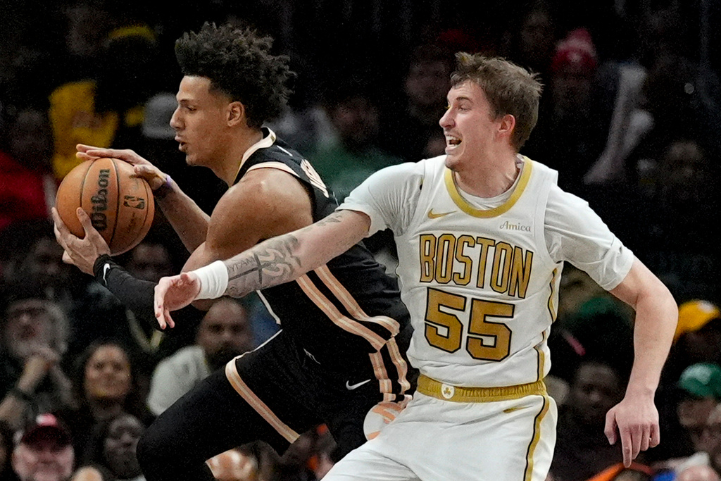Atlanta Hawks forward Jalen Johnson (1) takes a rebound against Boston Celtics guard Baylor Scheierman (55) during the first half of an NBA basketball game, Saturday, Jan. 17, 2026, in Atlanta. (AP Photo/Mike Stewart)