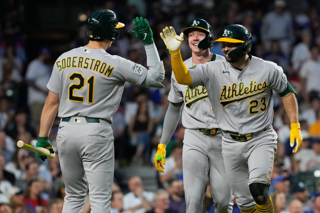 Athletics' Shea Langeliers (23), celebrates with Tyler Soderstrom (21) after hitting a two-run inside-the-park home run during the sixth inning of a baseball game against the Chicago Cubs in Chicago, Thursday, June 4, 2026. (AP Photo/Nam Y. Huh)