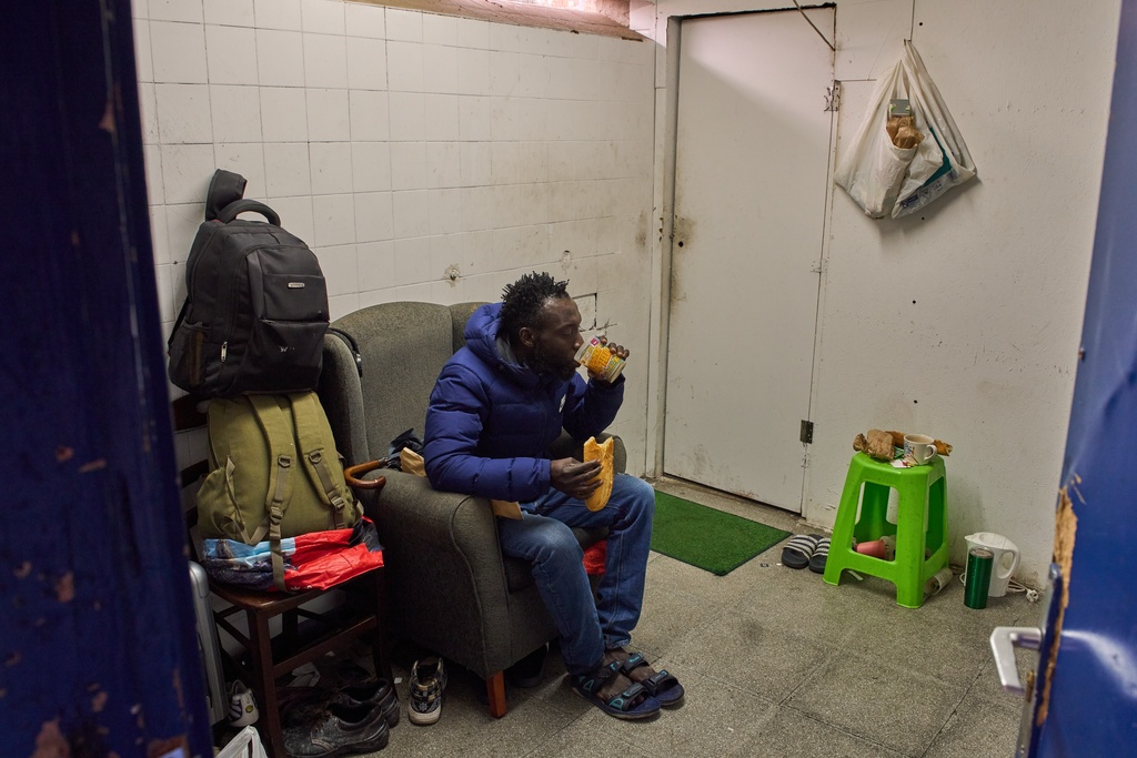 FILE - Yankuba Touray, from Gambia, eats his breakfast inside an abandoned school in Badalona, near Barcelona, Spain, Tuesday, Dec. 16, 2025. (AP Photo/Emilio Morenatti, File)