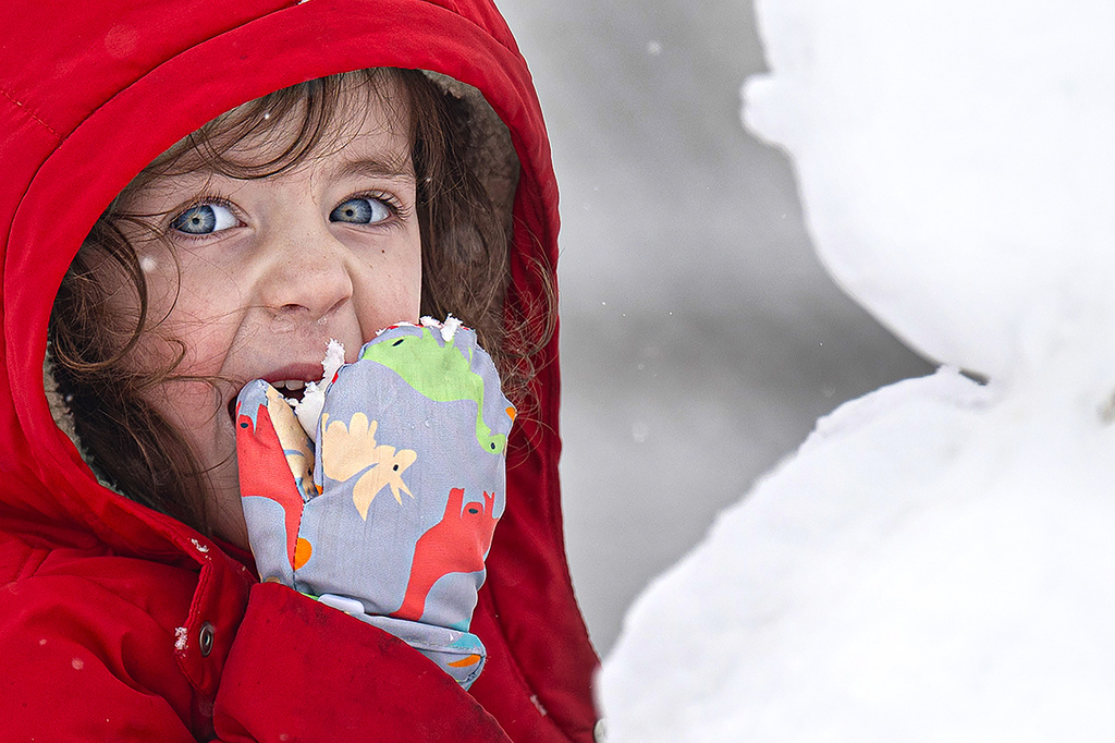 Louise Jordan, 3, eats snow while building a snowman near her home in Media, Pa. on Monday, Feb. 23, 2026. (Jose F. Moreno/The Philadelphia Inquirer via AP)