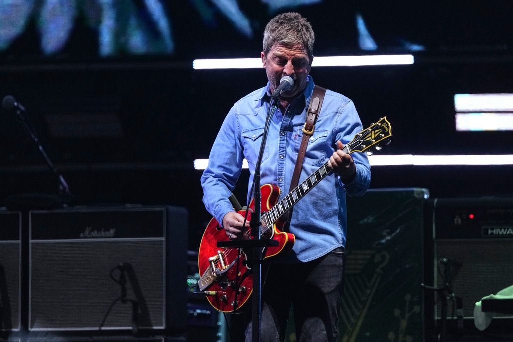 Noel Gallagher from the band Oasis plays his guitar as they perform during their reunion concert on Friday, July 4, 2025, in Cardiff. (Photo by Scott A Garfitt/Invision/AP)