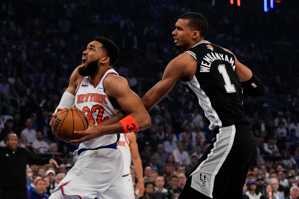 New York Knicks center Karl-Anthony Towns (32) drives past San Antonio Spurs forward Victor Wembanyama during first half of Game 4 of the NBA Finals basketball series, Wednesday, June 10, 2026, in New York. (AP Photo/Ross D. Franklin)