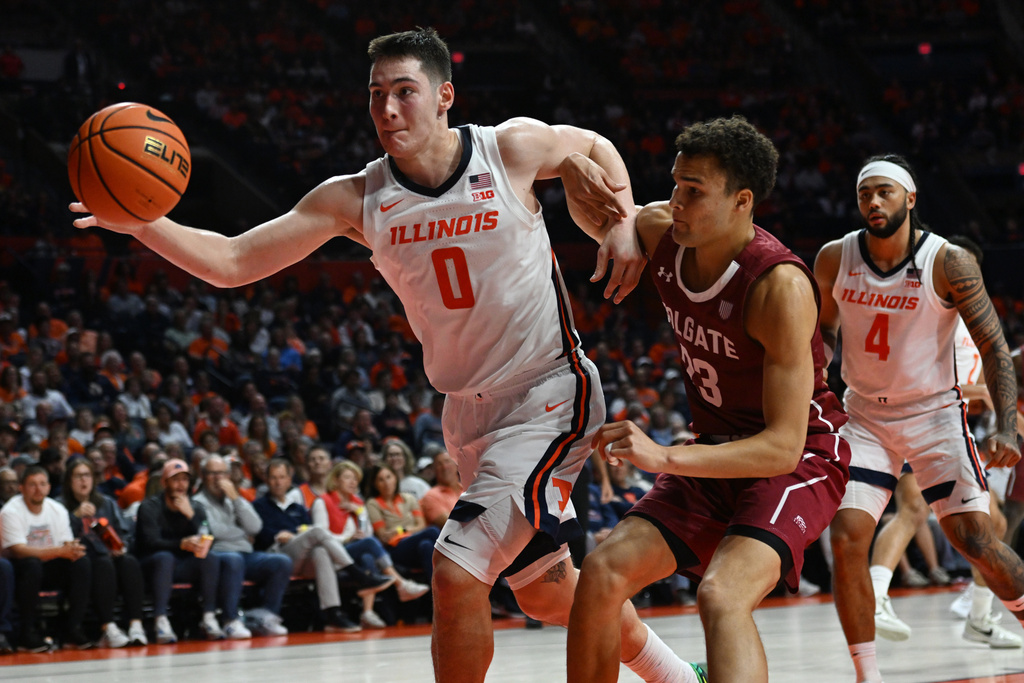 Illinois' David Mirkovic (0) saves an out of bounds ball against Colgate's Cooper Wright (23) during the second half of an NCAA basketball game Friday, Nov. 14, 2025, in Champaign, Ill. (AP Photo/Paul Beaty)