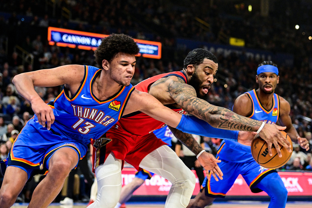 New Orleans Pelicans guard/forward Saddiq Bey (41) goes for the free ball against Oklahoma City Thunder forward Ousmane Dieng (13) during the first half of an NBA basketball game Tuesday, Jan. 27, 2026, in Oklahoma City. (AP Photo/Gerald Leong)