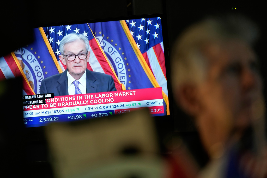 A television displays a news conference with Fed chairman Jerome Powell on the floor at the New York Stock Exchange in New York, Wednesday, Dec. 10, 2025. (AP Photo/Seth Wenig)