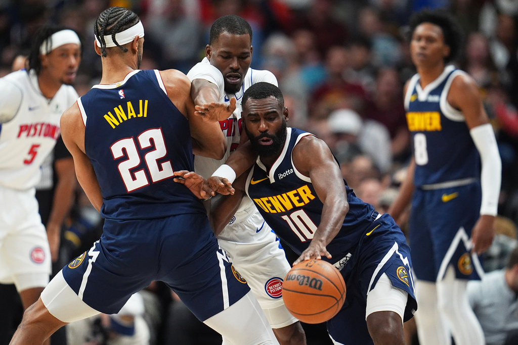 Denver Nuggets guard Tim Hardaway Jr., right, drives past Detroit Pistons guard Javonte Green, center, as Denver center Zeke Nnaji sets a pick in the first half of an NBA basketball game, Tuesday, Jan. 27, 2026, in Denver. (AP Photo/David Zalubowski)