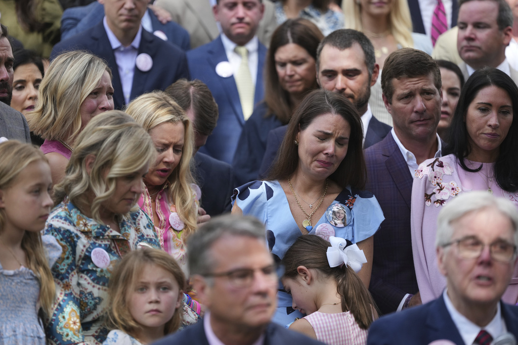 Parents and family of children who died at Camp Mystic, join Texas Gov. Greg Abbott as he signs camp safety bills, Friday, Sept. 5, 2025, in Austin, Texas. (AP Photo/Eric Gay)