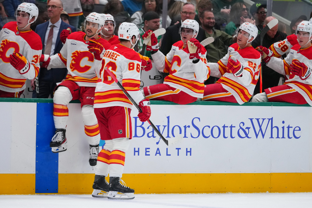 Calgary Flames left wing Joel Farabee (86) skates by his bench after scoring a goal against the Dallas Stars during the second period of an NHL hockey game Tuesday, April 7, 2026, in Dallas. (AP Photo/Julio Cortez)