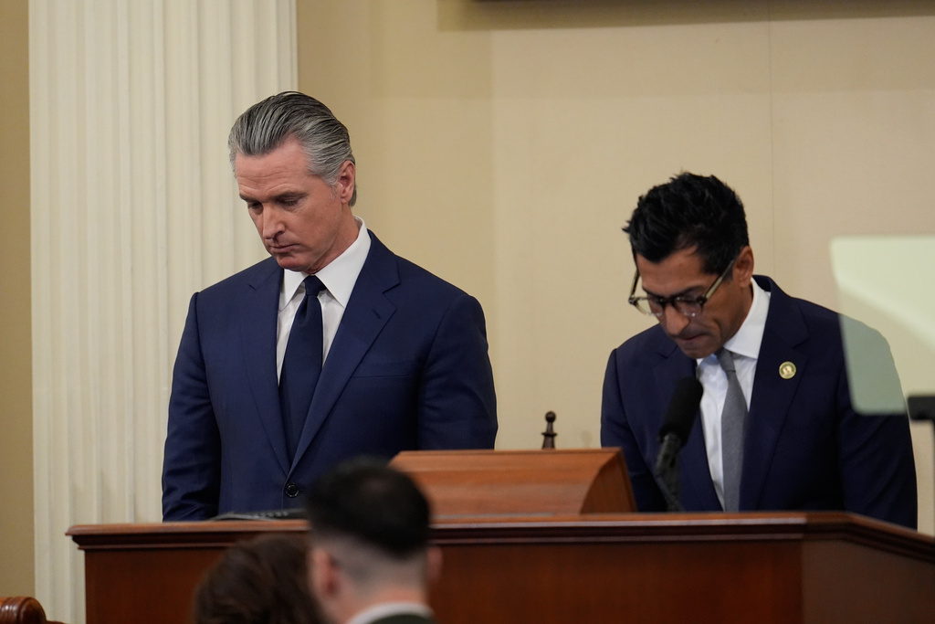 California Gov. Gavin Newsom, left, takes part in a moment of silence for the victim of a fatal shooting involving federal law enforcement agents in Minnesota, alongside California Assembly Speaker Robert Rivas, right, before his State of the State address Thursday, Jan. 8, 2026, in Sacramento, Calif. (AP Photo/Godofredo A. Vásquez)