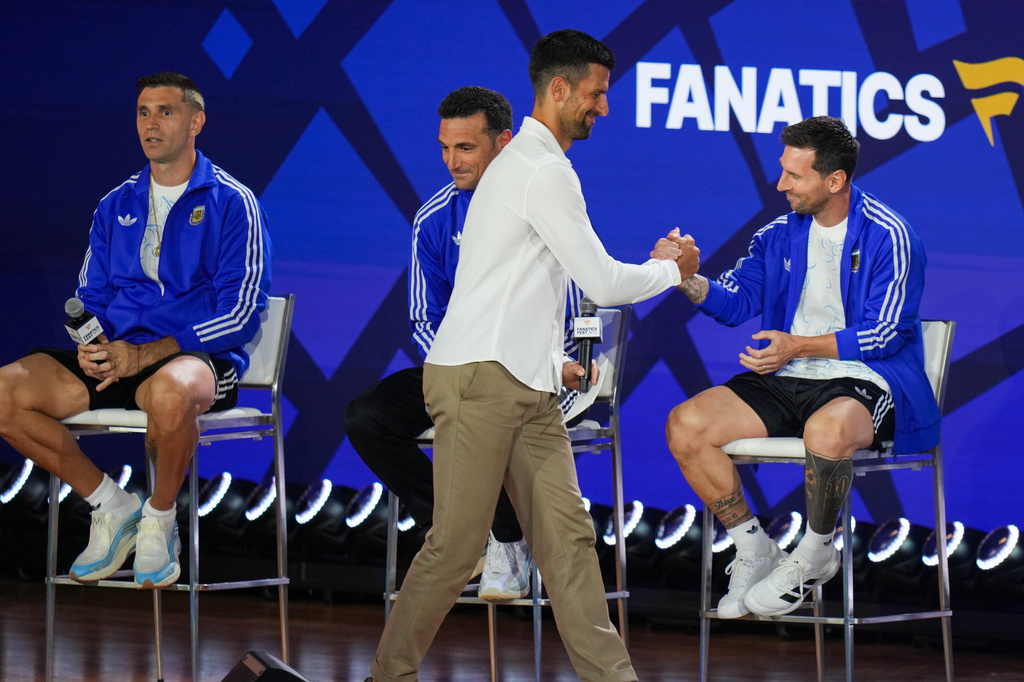 Tennis player Novak Djokovic greets Argentina's Lionel Messi as goalkeeper Emiliano Martinez, left, and head coach Lionel Scaloni look on during a news conference ahead of the World Cup final soccer match between Spain and Argentina in New York, Friday, July 17, 2026. (AP Photo/Stephanie Scarbrough)