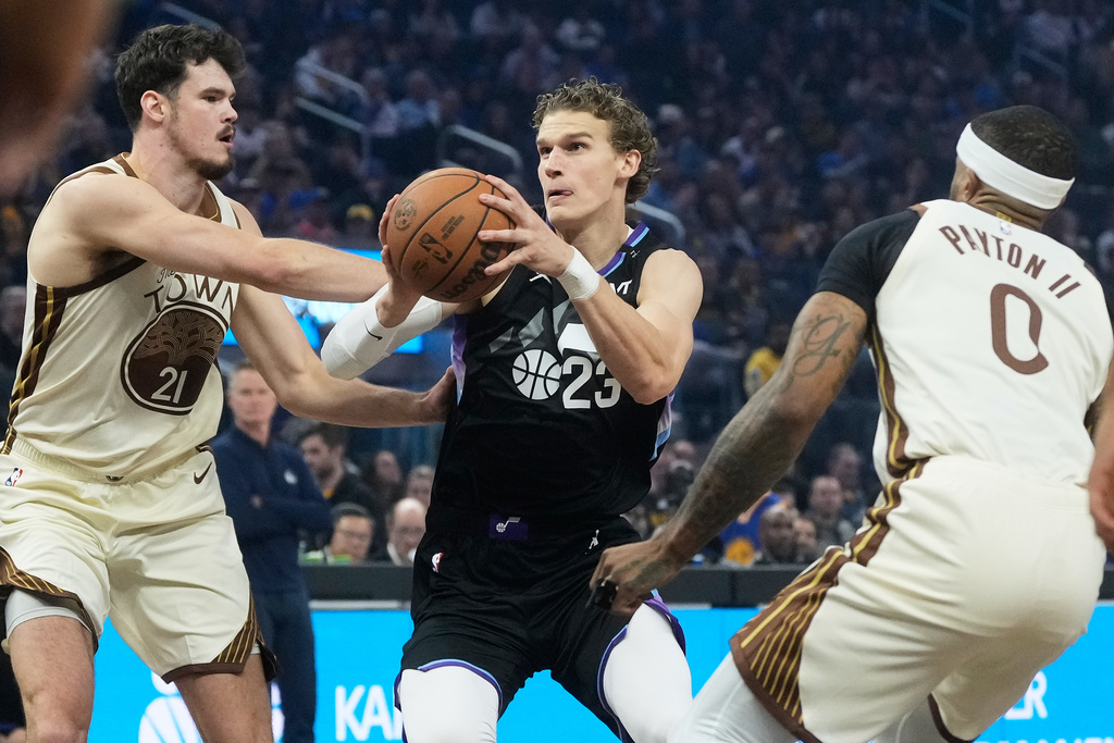 Utah Jazz forward/center Lauri Markkanen, middle, drives to the basket against Golden State Warriors center Quinten Post (21) and guard Gary Payton II (0) during the first half of an NBA basketball game in San Francisco, Monday, Nov. 24, 2025. (AP Photo/Jeff Chiu)