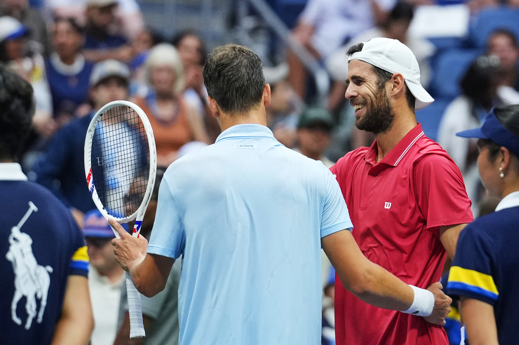 Alexander Blockx, of Belgium, left, meets Karen Khachanov, of Russia, at the net after Blockx was forced to retire due to an apparent injury during the quarterfinal round of the U.S. Open tennis championships, Wednesday, Sept. 9, 2026, in New York. (AP Photo/Kirsty Wigglesworth)