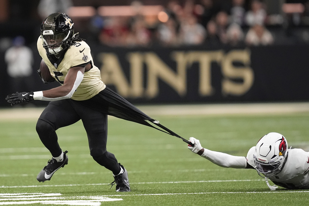 New Orleans Saints running back Kendre Miller, left, pulls away from Arizona Cardinals cornerback Garrett Williams during the first half of an NFL football game Sunday, Sept. 7, 2025, in New Orleans. (AP Photo/Gerald Herbert)