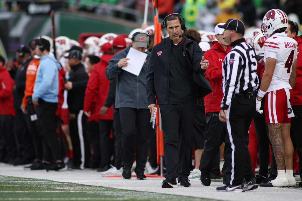 Wisconsin head coach Luke Fickell, third from front right, walks the sideline during the first half of an NCAA college football game against Oregon, Saturday, Oct. 25, 2025, in Eugene, Ore. (AP Photo/Lydia Ely)