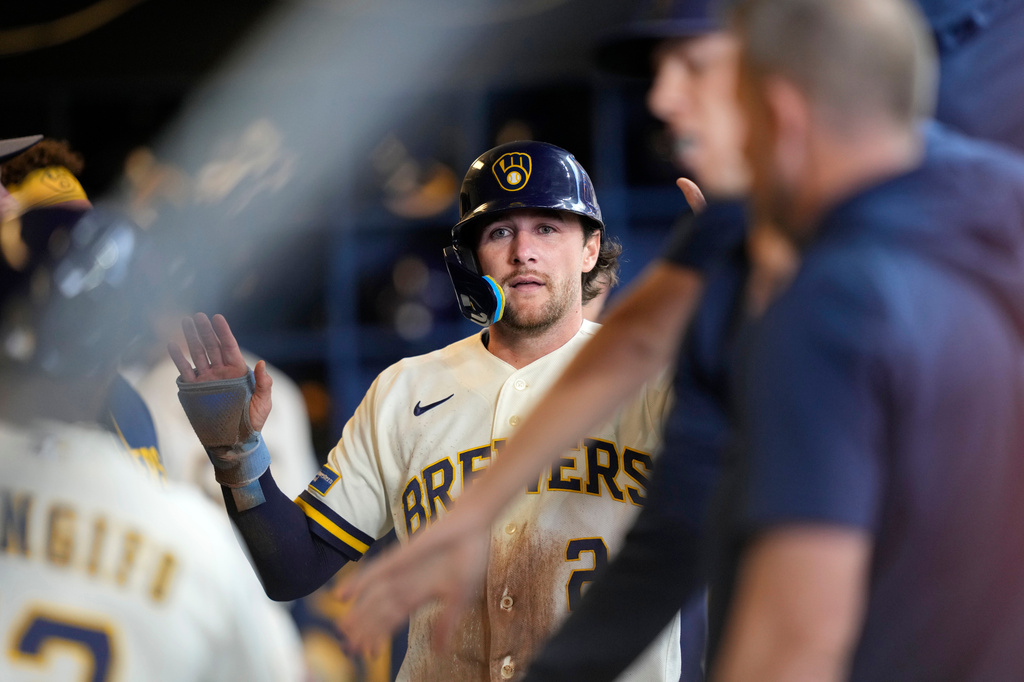 Milwaukee Brewers' Brice Turang high-fives teammates after scoring on a sacrifice fly by Luis Rengifo during the fourth inning of a baseball game against the Toronto Blue Jays, Thursday, April 16, 2026, in Milwaukee. (AP Photo/Kayla Wolf)