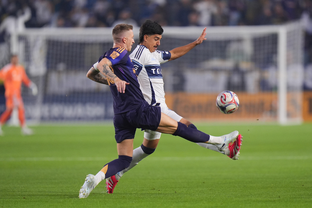 Los Angeles Galaxy midfielder Marco Reus, left, and Vancouver Whitecaps defender Mathias Laborda chase the ball during the first half of an MLS soccer match Saturday, May 2, 2026, in Carson, Calif. (AP Photo/Jae C. Hong)