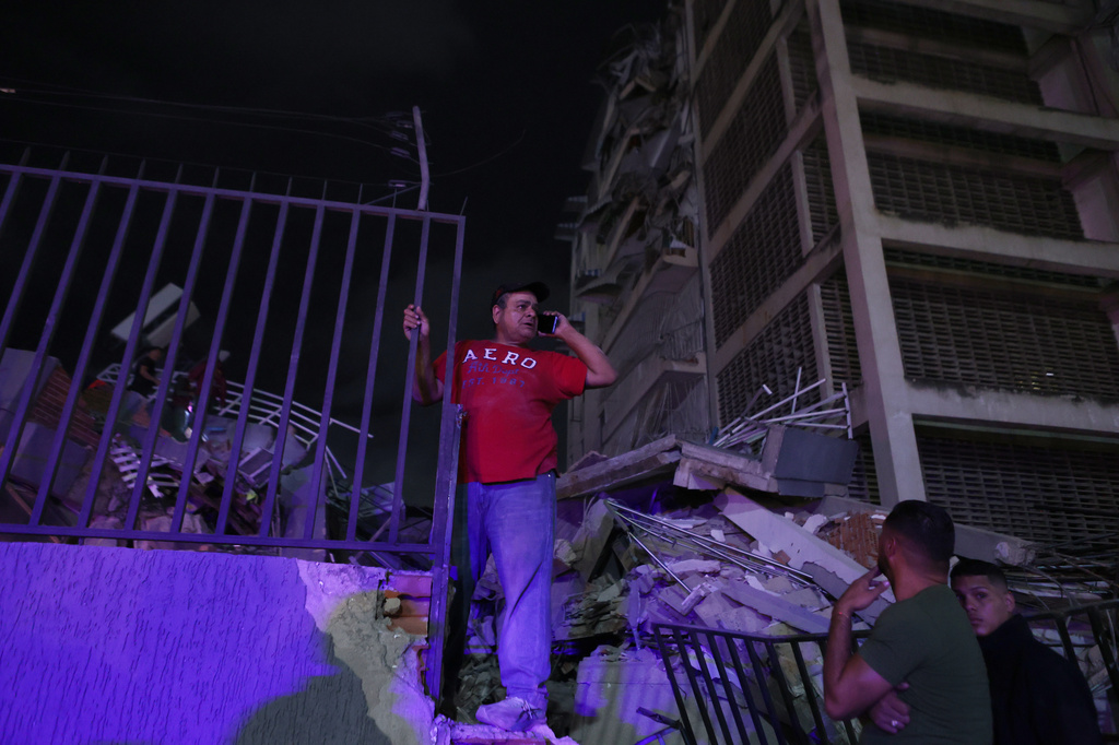 A man tries to make a call after an earthquake in Caracas, Venezuela, Wednesday, June 24, 2026. (AP Photo/Pedro Mattey)