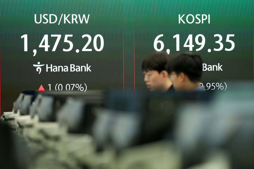 Dealers talk near the screen showing the Korea Composite Stock Price Index (KOSPI), right, and the foreign exchange rate between U.S. dollar and South Korean won at a dealing room of Hana Bank, in Seoul, South Korea, Thursday, April 16, 2026. (AP Photo/Lee Jin-man)