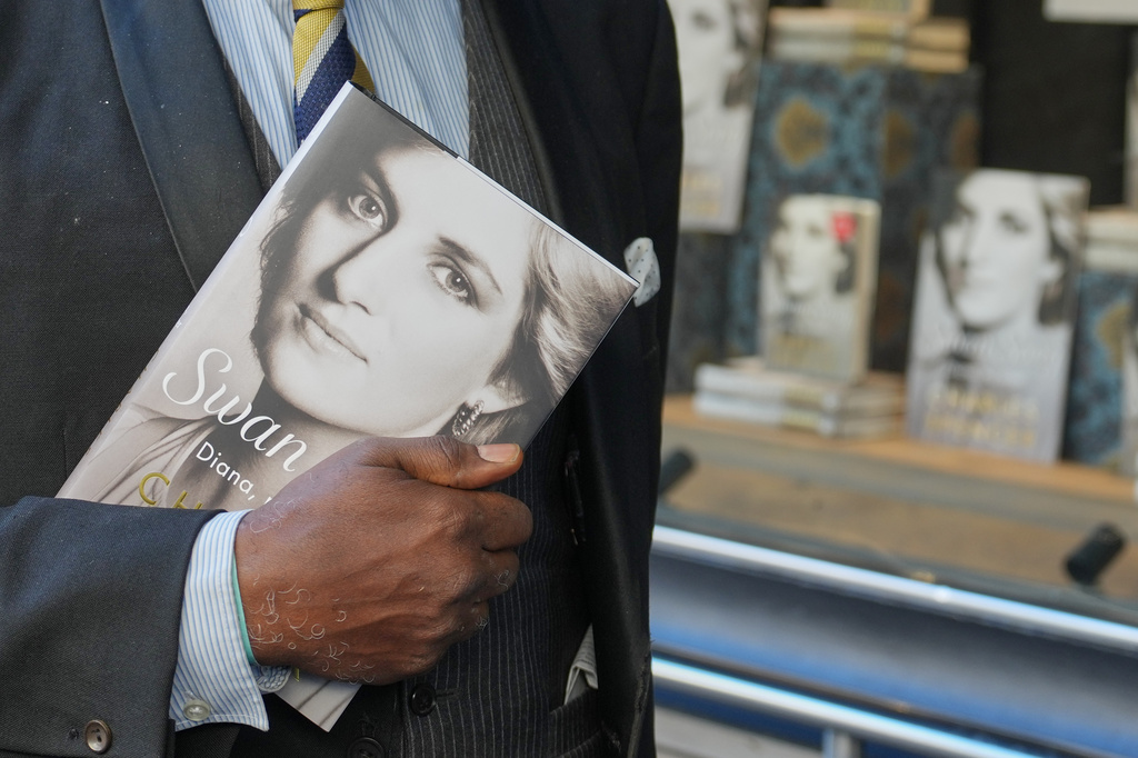 A man holds a copy of the new book by Earl Spencer, brother of the late Princess Diana, entitled "Swan Song: Diana, My Sister," outside a bookshop in central London, Tuesday, Sept. 22, 2026. (AP Photo/Kin Cheung)