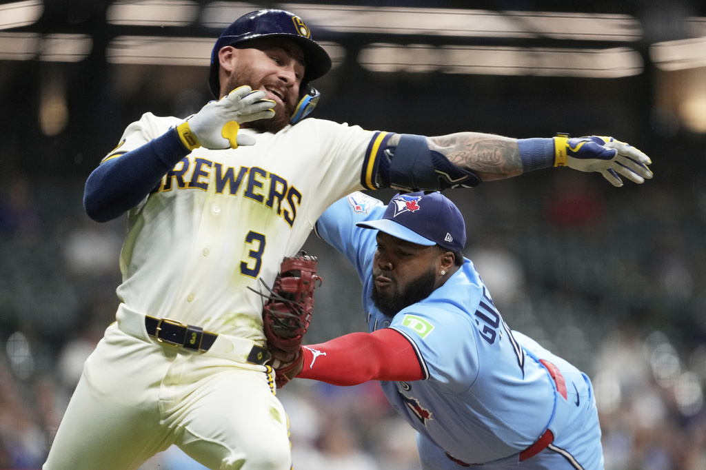 Toronto Blue Jays' Vladimir Guerrero Jr., right, tags out Milwaukee Brewers' Joey Ortiz during the eighth inning of a baseball game Tuesday, April 14, 2026, in Milwaukee. (AP Photo/Aaron Gash)