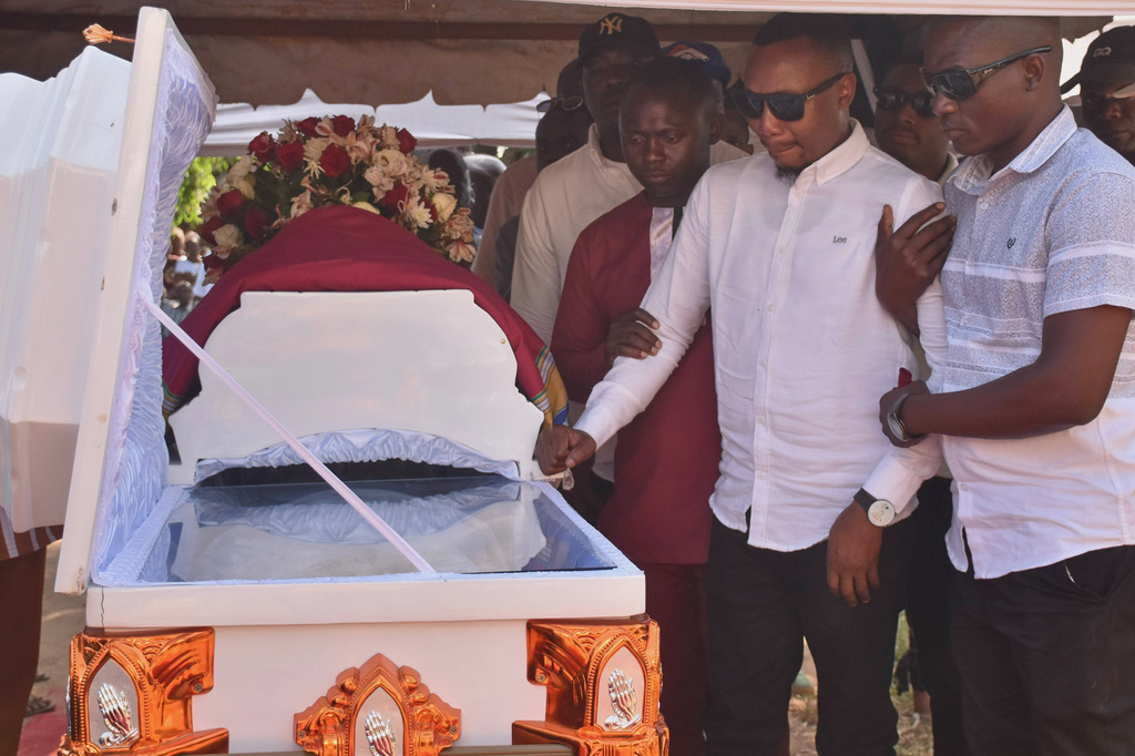 Adams Kahindi, center, mourns beside the coffin of his wife, Penina Zawadi, who died from complications related to childbirth, in Kilifi County, Kenya, Saturday, July 18, 2026. (AP Photo/Brian Wachira)