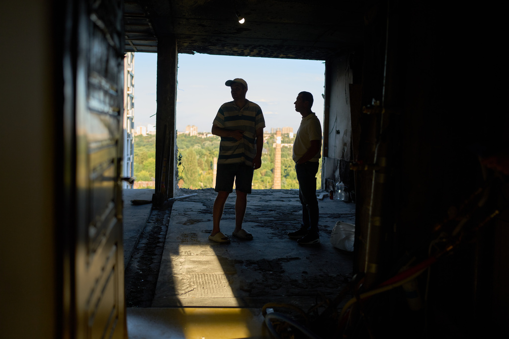 Ivan Datsiv, left, talks to a friend inside his apartment the day after a Russian drone attack struck his building in Kyiv, Wednesday, Sept. 2, 2026. (AP Photo/Francisco Seco)