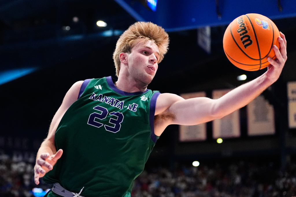Green Bay forward Caden Wilkins grabs a rebound during the first half of an NCAA college basketball game against Kansas, Monday, Nov. 3, 2025, in Lawrence, Kan. (AP Photo/Charlie Riedel)