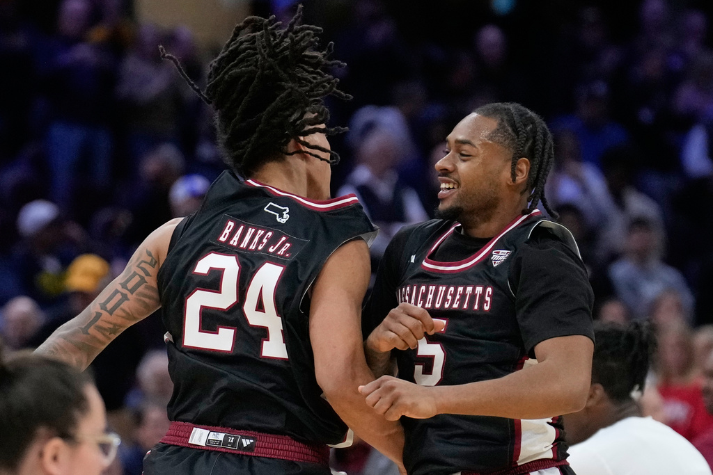 Massachusetts guard Marcus Banks (24) and guard K'jei Parker (5) celebrate after Massachusetts defeated Miami (Ohio) in a basketball game in the quarterfinals of the Mid-American Conference tournament, Thursday, March 12, 2026, in Cleveland. (AP Photo/Sue Ogrocki)