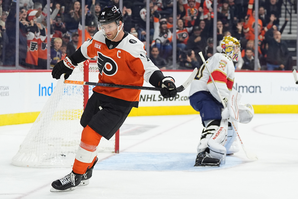 Philadelphia Flyers' Sean Couturier, left, skates past Florida Panthers goaltender Daniil Tarasov, right, after scoring during the second period of an NHL hockey game, Monday, Oct. 13, 2025, in Philadelphia. (AP Photo/Matt Rourke)