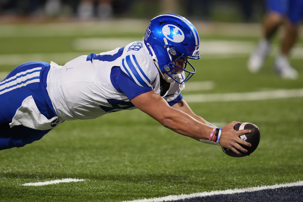 BYU quarterback Bear Bachmeier dives for a touchdown in the second overtime against Arizona during an NCAA college football game, Saturday, Oct. 11, 2025, in Tucson, Ariz. (AP Photo/Rick Scuteri)
